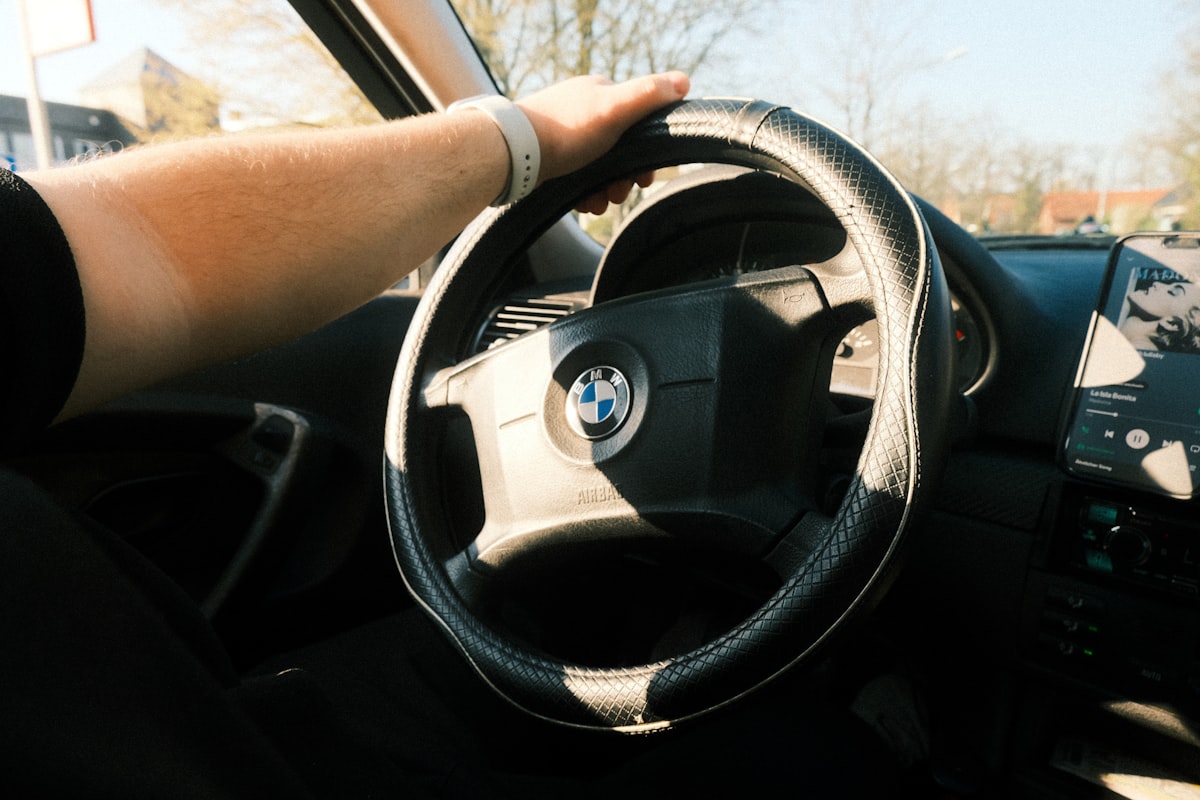 Ruka na volante auta počas jazdy za denného svetla